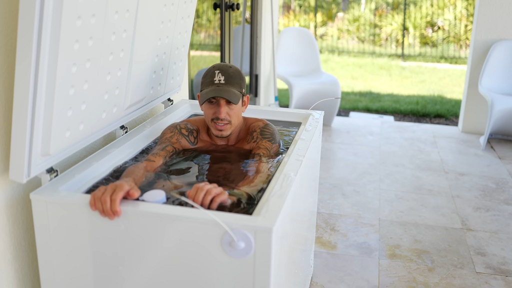 The guy is submerged in a tub with ice-cold water